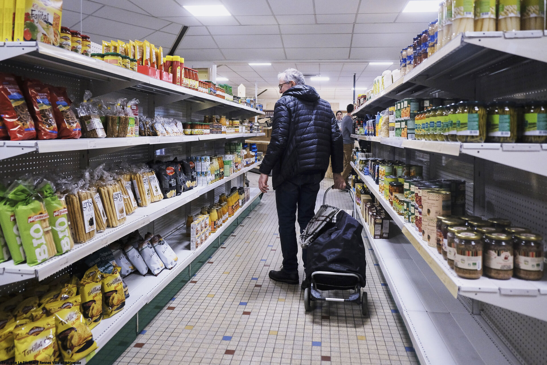 Client marchant dans le rayon d'un supermarché